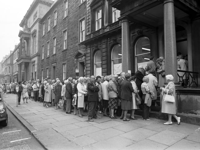 Edinburgh pensioners queue outside the office in Queen Street Edinburgh to apply for the special OAP's bus ticket from Lothian Region in August 1983.