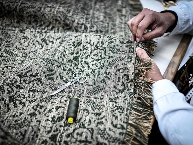 An employee works on a couture garment