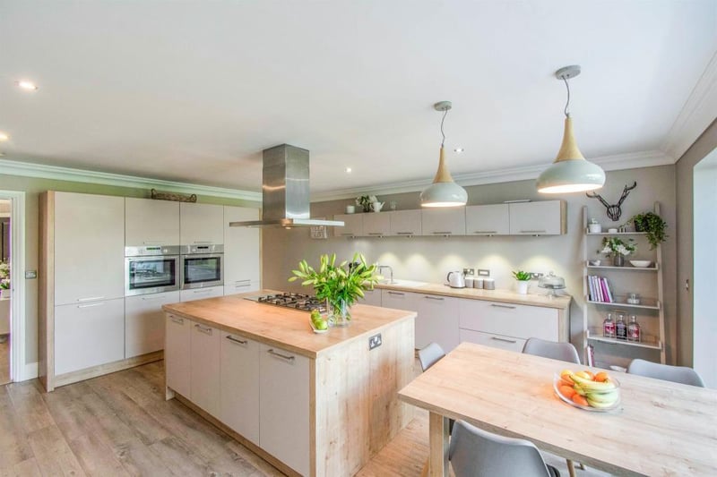 Breakfast kitchen with  a focal breakfast island with a five ring gas hob with extractor fan above with high finish soft closing base units and extensive island worktop space that provides a superb family space