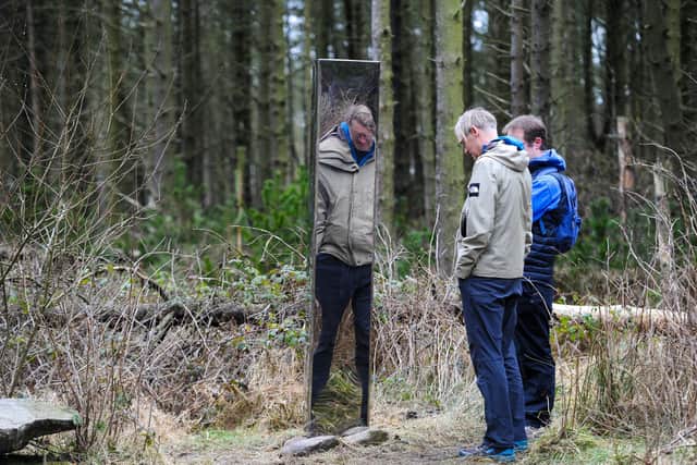 Walkers look at the metal monolith which has appeared in Lady Canning's Plantation in Sheffield. Picture: Dean Atkins