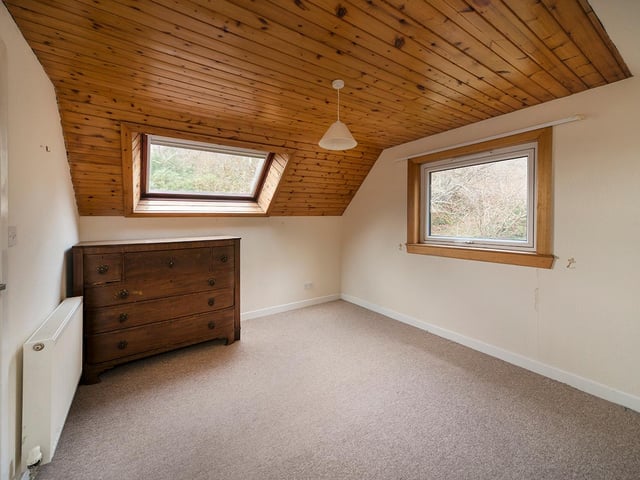One of the bedrooms, which boats windows on two sides offering views across the stunning landscape