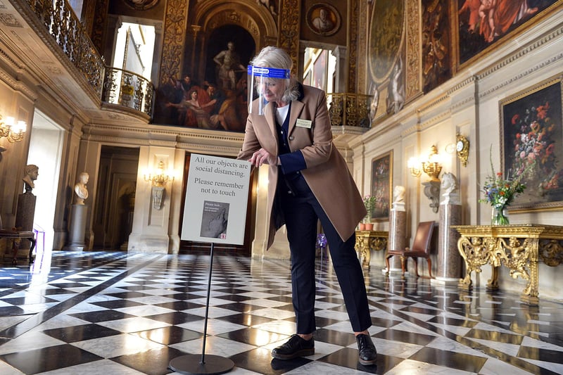 Lizzie Ross, visitor welcome supervisor, places new signs for social distancing in the Painted Hall at Chatsworth in July in readiness to welcome back the public after lockdown.