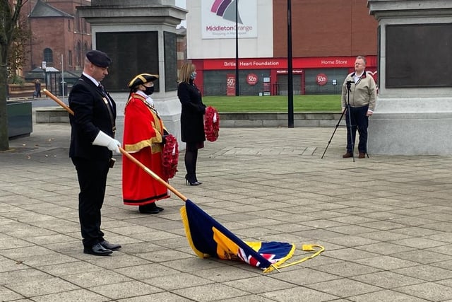 Standard bearer lowers the flag in a moment of quiet reflection.
