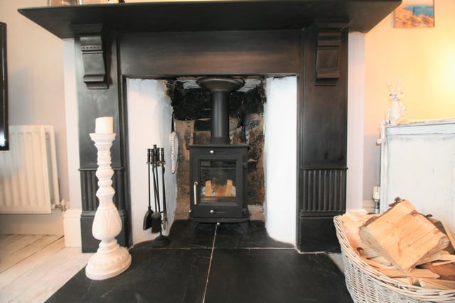 The living room has a log burner and feature fireplace.