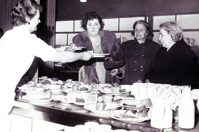 An emergency gale centre was set up in Hurlfield Secondary Boys School for families made homeless by the gales.  Our picture shows some of the homeless receiving emergency meals laid on by the school meals staff at the centre, February 1962