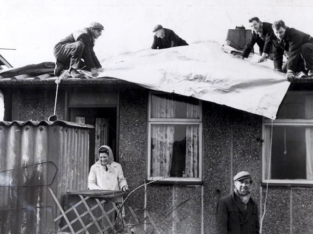 A gale affecting the eastern Pennines wreaked havoc in Sheffield on February 16, 1962, with wind speeds hitting 96mph. Trees were uprooted and over 100,000 buildings were damaged, while four people were killed and 6,000 left without homes. Residents of Skye Edge Avenue are pictured as tarpaulin is laid on February 17.