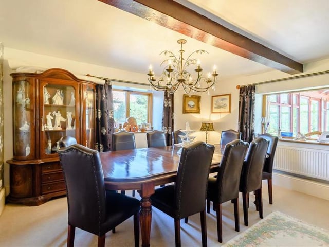 The dining room oozes class and elegance. It boasts a fine fireplace with an inset multi-fuel stove, stone hearth and mantle above, plus a central beamed ceiling and double-glazed windows to the side and rear.