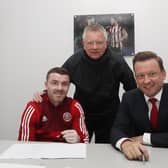John Fleck, alongside Chris Wilder (C) and chief executive Steve Bettis(R) signs his new contract with Sheffield United: Simon Bellis/Sportimage