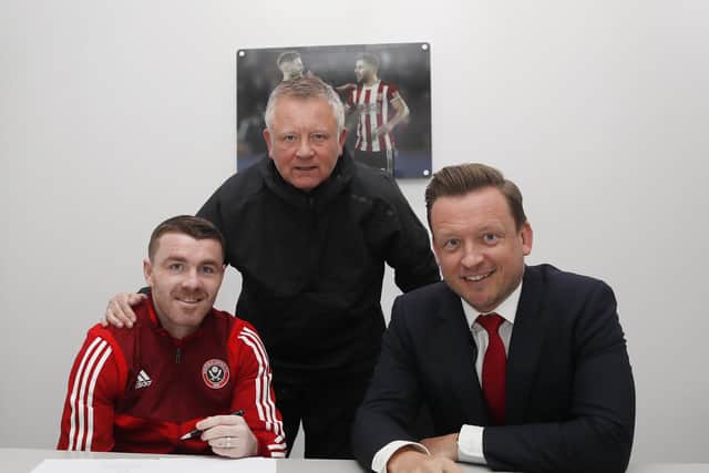 John Fleck, alongside Chris Wilder (C) and chief executive Steve Bettis(R) signs his new contract with Sheffield United: Simon Bellis/Sportimage