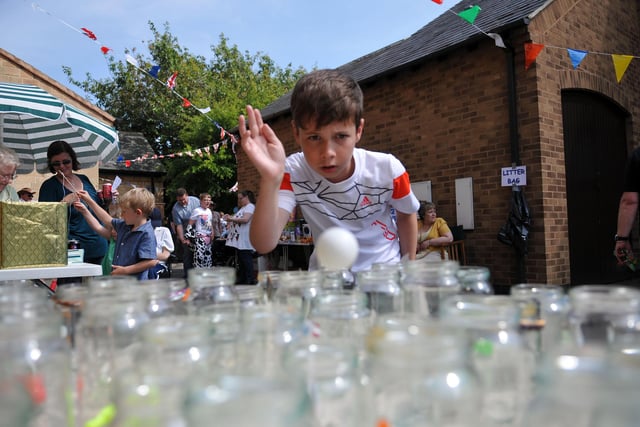 George Reed attempts to throw a ping pong ball into a jar during the St Luke's garden party in 2013.