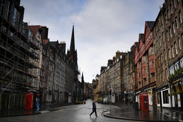 Members of the public walk through a deserted Edinburgh City Centre on January 4, 2021 in Edinburgh, Scotland.