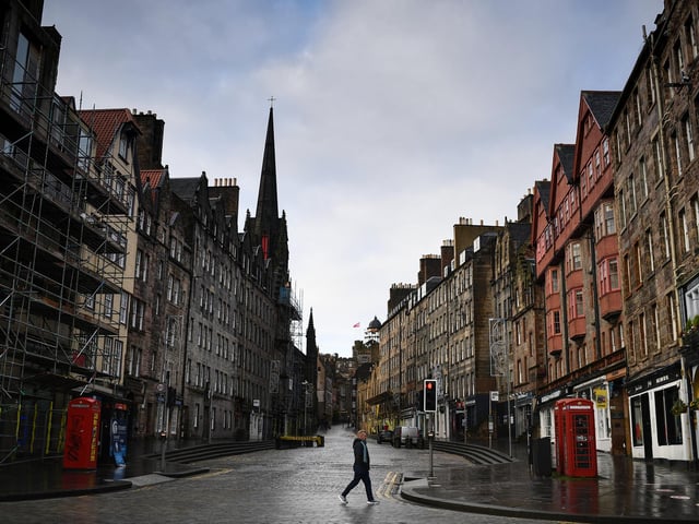 Members of the public walk through a deserted Edinburgh City Centre on January 4, 2021 in Edinburgh, Scotland.