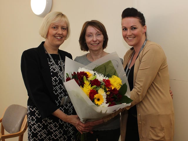 Pauline Gibbon (centre) retired as a dinner lady from Littlemoor Children's Centre and Infant School after 29 years, she is pictured in 2014 receiving flowers from the headteacher Carol Ann Turner (l) and Amy Patrick, who was a pupil at the school when Pauline was started as a dinner lady