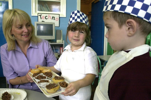 Charlotte Walker and Joshua Rose (both 4) served teacher Lynn Packer at the lunchtime cafe in the reception class at Manor Lodge Primary School in 2003