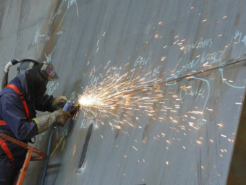 A ship builder works on a section of HMS Queen Elizabeth at BAE Systems in Portsmouth in December 2010. She was built in parts at sites across the country including our city, Glasgow and Rosyth. Picture: Chris Ison/PA Wire