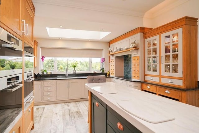 The kitchen is expertly finished with bespoke cabinets and the worktops made of corian and granite.