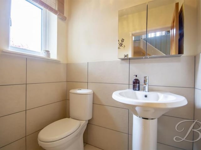 Fitted with a modern suite in white comprising; low level WC and a pedestal wash hand basin, benefiting from complementary tiled splash backs. With an opaque window.