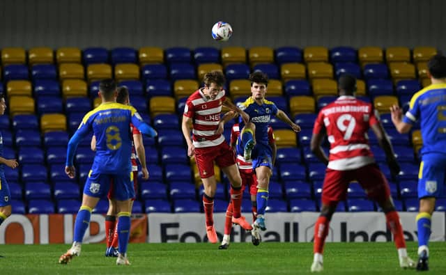 Tom Anderson rises to head the ball.
