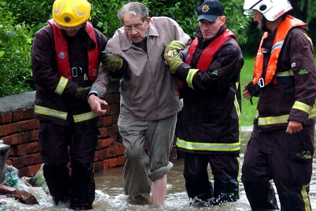 Firefighters help an elderly man to safety in Ecclesfield