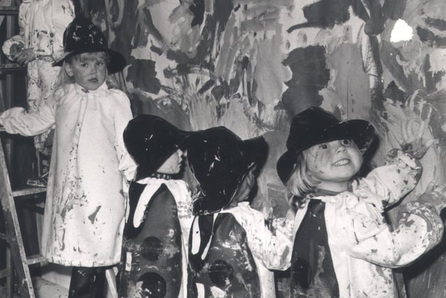 Toddlers of Dronfield Woodhouse Playgroup help to paint the background of a window at Walsh's to promote a painting competition organised by "Ladybird" Childrens Clothes Manufacturers in 1974