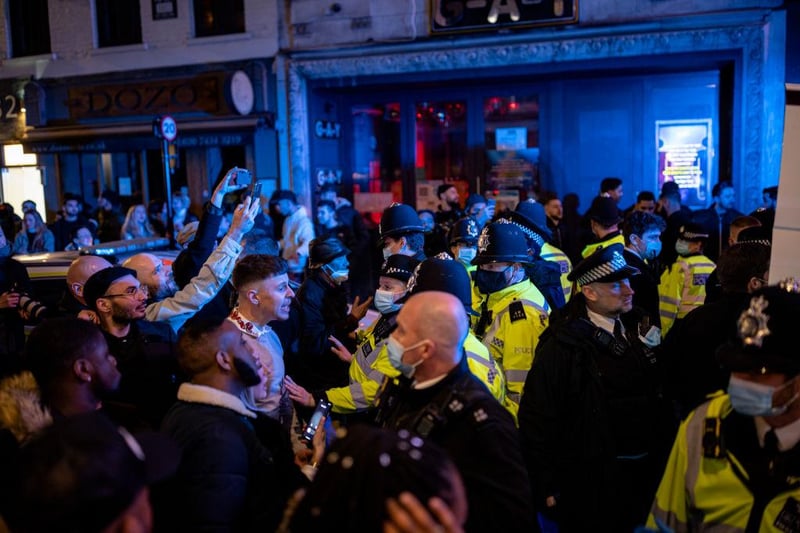 Police officers attempt to keep the crowd away from a police van after a man was arrested on Old Compton Street in Soho on April 16, 2021 in London, England. (Photo by Rob Pinney/Getty Images)