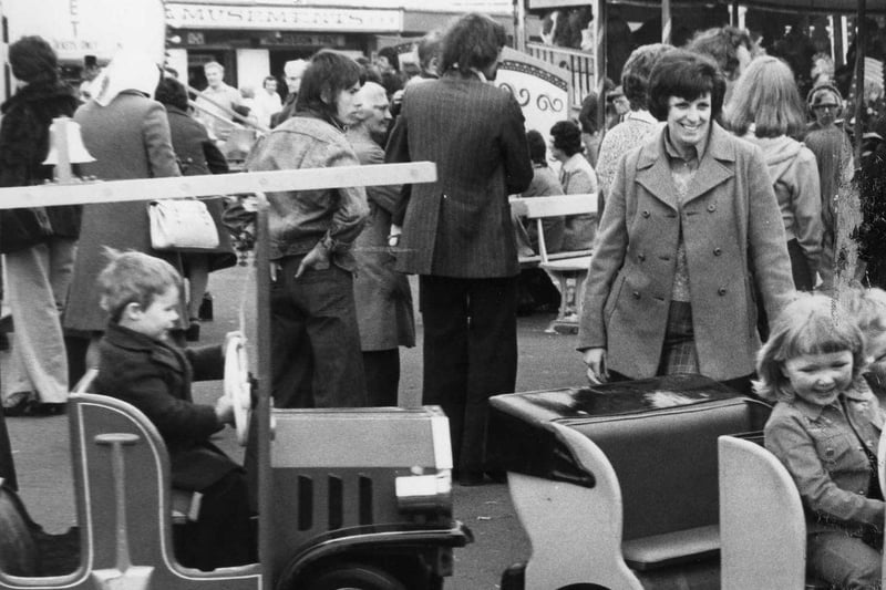 A 1976 photo and these children were loving the amusements while the parents looked on.