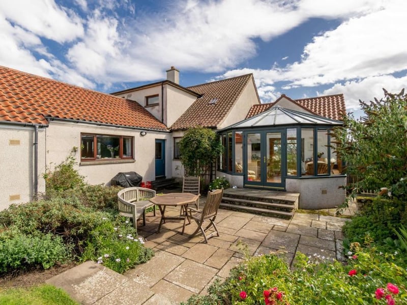 The conservatory leads out to a sheltered patio area.