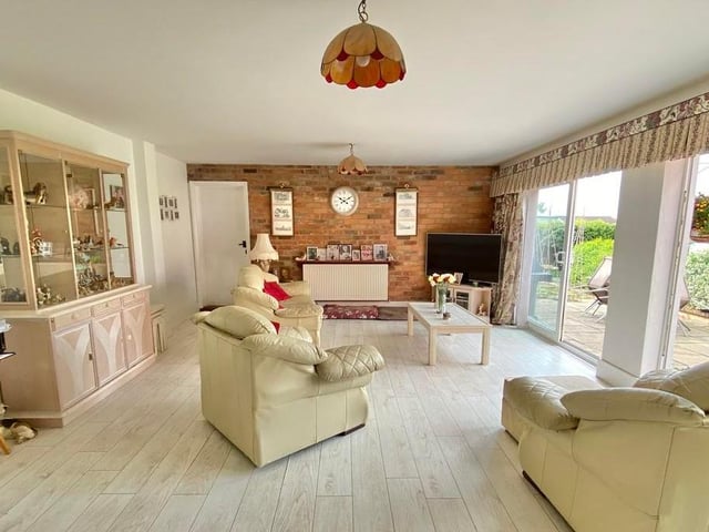 This large sitting-room features two sets of patio doors that open out on to the back garden. With exposed brick walls, it is full of charm.