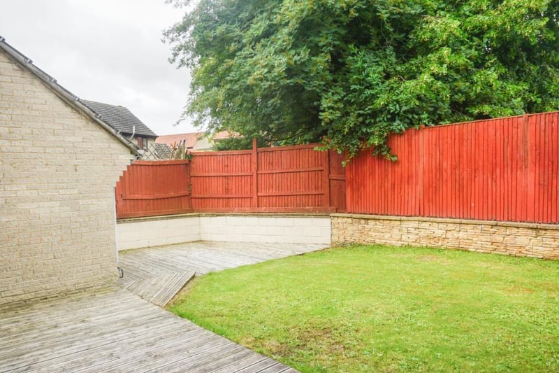 Fully enclosed rear garden with fencing and walling, part of the wall is for convenient seating around the patio, good size decked area perfect for a table and chairs to dine al fresco, and rest of the garden is laid to lawn.