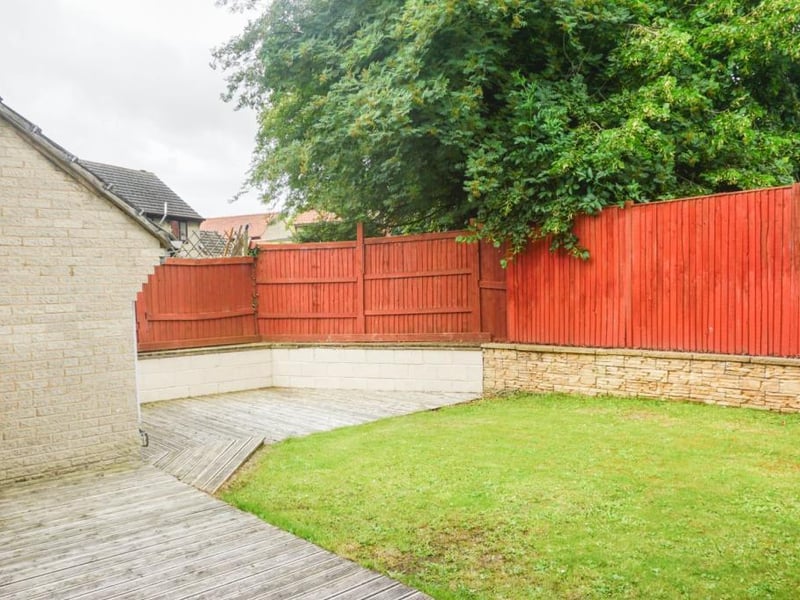 Fully enclosed rear garden with fencing and walling, part of the wall is for convenient seating around the patio, good size decked area perfect for a table and chairs to dine al fresco, and rest of the garden is laid to lawn.