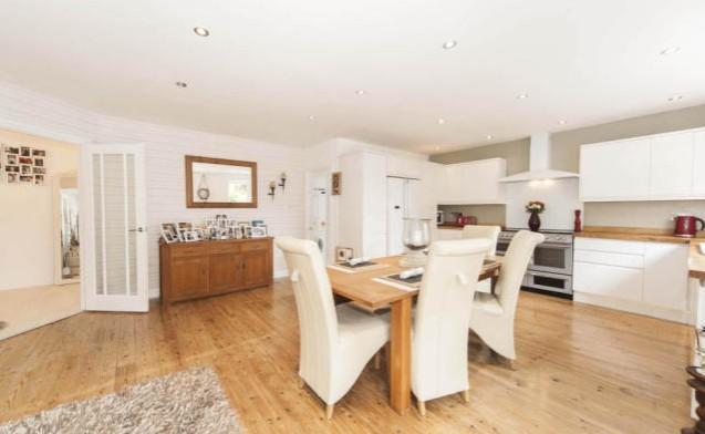 The contemporary kitchen/dining room is fitted with high standard features including wall and base units, glass splash back, wooden work surfaces, oak flooring, modern designer radiator and double doors to the back garden.