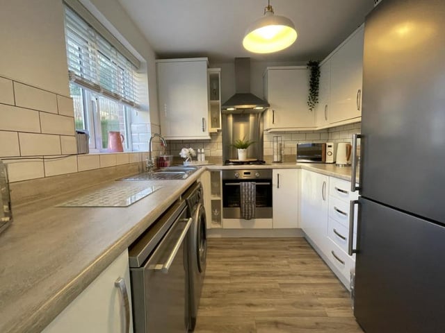 This is the busy main body of the kitchen, which features an integrated electric oven and gas hob, plus space for a fridge/freezer, a washing machine and dishwasher. Fitted wall and base units with drawer units are complemented by roll-top work surfaces and a one-and-a-half bowl stainless steel sink and drainer with mixer tap.