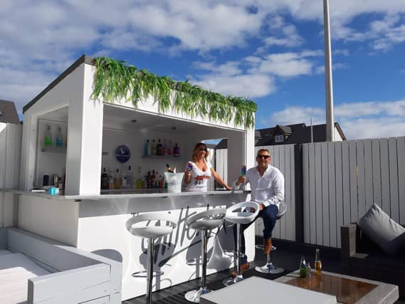 Mike Braid enjoys a drink at his homemade garden bar.