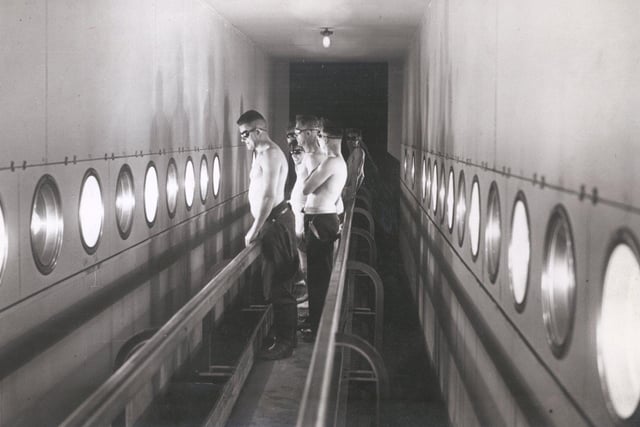 Miners on conveyor belts passing rows of sunray lamps at Manvers Main Colliery solarium in May 1942