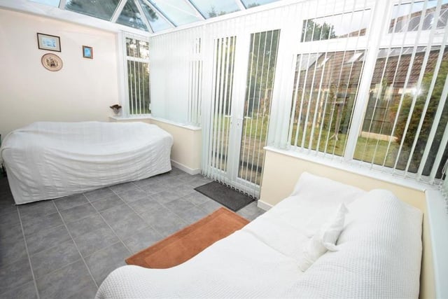 Although the seats are covered, this photo gives a good idea of how bright and airy the conservatory is. It is a versatile space with practical, tiled flooring and doors opening out to the back garden.