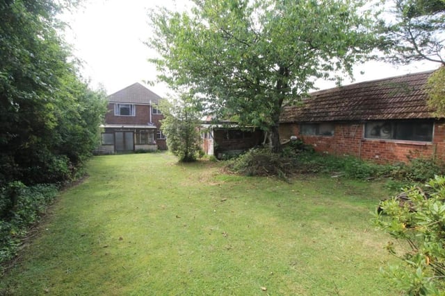 The rear garden is lawned,  has mature trees and a shed. There is a detached garage at the back of the house.