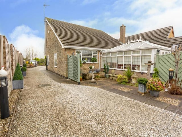 A view from the garage shows the property's long driveway, offering plenty of private parking space.