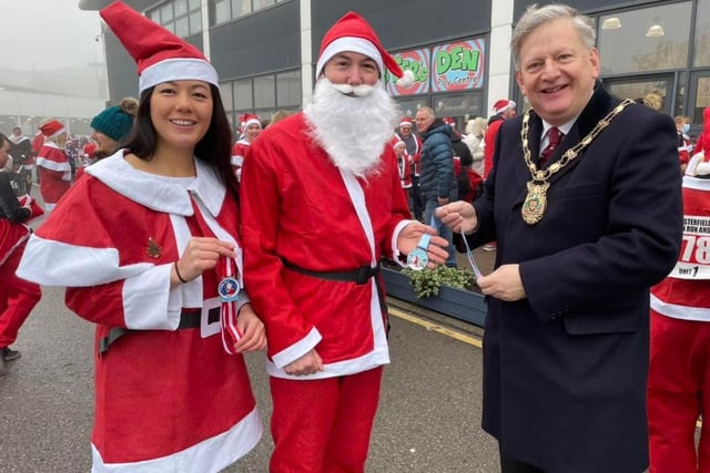 Councillor Martin Thacker MBE, chair of North East Derbyshire District Council, presenting medals to two of the Santas