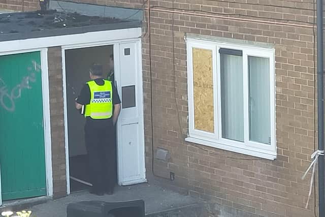 A police officer guards one of the houses on Fox Hill Road that have been sealed as part of a murder investigation.