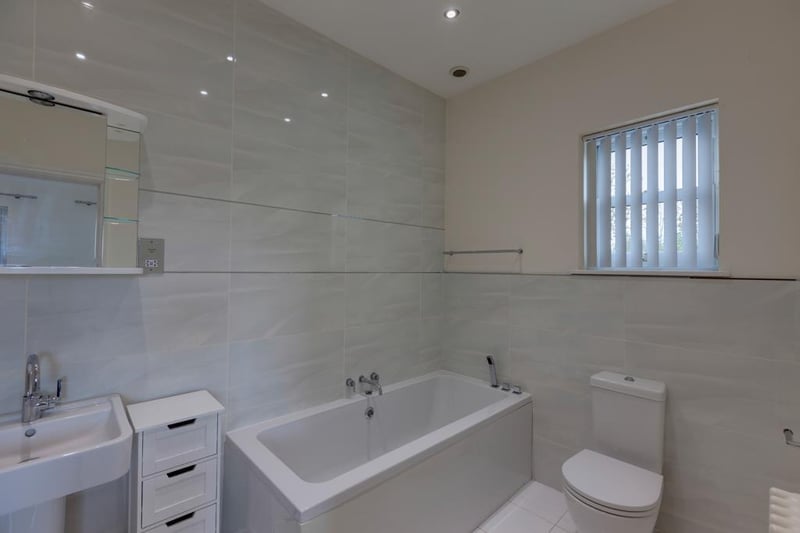The ensuite for bedroom three has a suite in white, which comprises of a low-level WC and a pedestal wash hand basin with mirrored vanity mirror above. To one corner, there is a panelled bath.