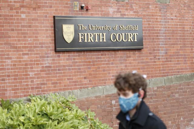 A man wearing a face covering walks past The University of Sheffield's Firth Court. PA Photo.
