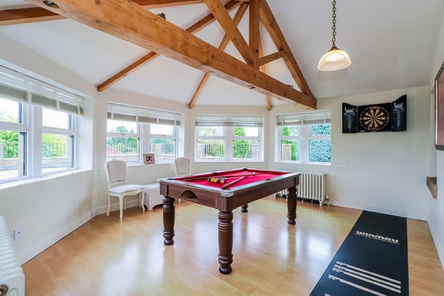 Currently used as a games room, this bright space benefits from wood effect laminate flooring, exposed beams and French doors leading to the outside entertaining area.