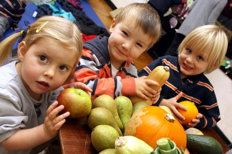 Rose Henning, Harry Goodley, and Alfie Buxton take part in Holloway Playgroup's harvest festival in 2010.
