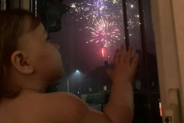 Hannah White shared this image of her child enjoying fireworks from a safe distance indoors.