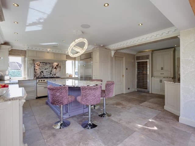 The modern dining kitchen has been fitted with bespoke wall and drawer units with matching granite work surfaces, and benefits from a central island, tiled flooring and a built-in sound system.