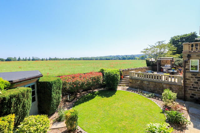 There are landscaped gardens to the front and rear of the property, with patio seating in both areas, and views across farmland at the back.