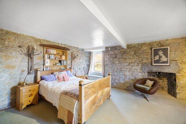 This bedroom, one of 10 in the house, boasts exposed stone walls