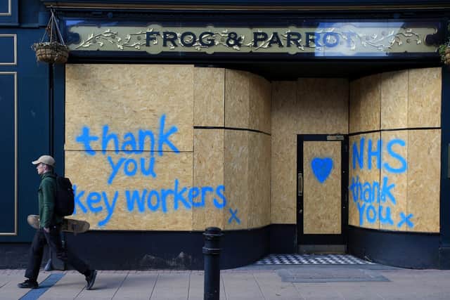 People walk past graffiti street art, praising the workers of Britain's NHS and other key workers, in Sheffield following an easing of the novel coronavirus COVID-19 lockdown guidelines. (Photo by Lindsey Parnaby / AFP) (Photo by LINDSEY PARNABY/AFP via Getty Images)
