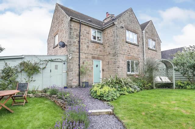 From Wheatland Lane, a tall wooden gate opens onto the front garden, where wooden sleeper steps wind up to the main lawn. The landscaped garden is well-stocked with mature plants and shrubs and has fantastic views toward Curbar Edge.