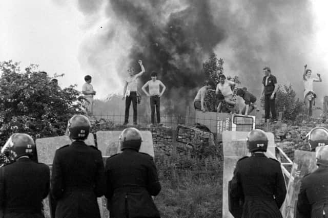 File photo dated 18 June 1984, of anti-riot squad police watching as pickets face them against a background of burning cars at the Orgreave coke works, Yorkshire. Photo: PA